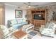Cozy living room featuring a decorative brick wall, comfortable seating, and a ceiling fan at 7005 River Hammock Dr # 303, Bradenton, FL 34212