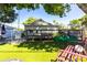 Lush green backyard with a patio, deck, swings, and mature trees at 717 84Th Nw St, Bradenton, FL 34209