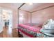 Bedroom featuring a decorative four-poster bed, hardwood floors, and bright window and an open door to living space at 717 84Th Nw St, Bradenton, FL 34209
