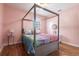 Comfortable bedroom features a four-poster bed, hardwood floors, and bright window at 717 84Th Nw St, Bradenton, FL 34209