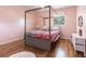 Charming bedroom with a decorative four-poster bed, hardwood floors and a bright window at 717 84Th Nw St, Bradenton, FL 34209