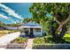 Charming single-story home with a white picket fence, lush landscaping, and a brick walkway leading to the front door at 717 84Th Nw St, Bradenton, FL 34209