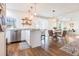 Bright kitchen with white cabinets, marble countertops, and hardwood floors, leading to an adjacent dining area at 717 84Th Nw St, Bradenton, FL 34209