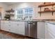 Bright kitchen featuring white cabinets, stainless steel appliances, granite countertops, and stylish open shelving at 717 84Th Nw St, Bradenton, FL 34209