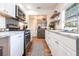 Well-lit kitchen with stainless steel appliances, white cabinetry, modern countertops, and hardwood floors at 717 84Th Nw St, Bradenton, FL 34209