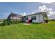 Exterior home view featuring lush green lawn with colorful manicured flowerbeds and garden at 74 Windsor Dr, Englewood, FL 34223