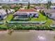 Waterfront backyard featuring a screened-in pool and lush landscaping at 74 Windsor Dr, Englewood, FL 34223