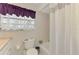 Bright bathroom featuring neutral tile, shower, toilet and a window with coverings at 74 Windsor Dr, Englewood, FL 34223