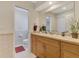 Bathroom featuring a vanity with a large mirror and a tiled area with a toilet at 74 Windsor Dr, Englewood, FL 34223