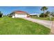 Lovely single-story home with a red tile roof, attached garage, and a beautifully maintained green lawn at 74 Windsor Dr, Englewood, FL 34223