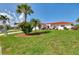 Picture-perfect home featuring a red tile roof, lush landscaping, and vibrant green lawn adding to its appeal at 74 Windsor Dr, Englewood, FL 34223
