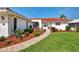 Charming home with a red tile roof, lush landscaping, and a welcoming walkway, showcasing curb appeal at 74 Windsor Dr, Englewood, FL 34223