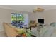 Bright living room with sliding glass doors, neutral walls, a ceiling fan, and views of the backyard and pool at 74 Windsor Dr, Englewood, FL 34223