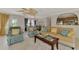Inviting living room with tile flooring, a ceiling fan, comfortable seating, and an open view to the kitchen at 74 Windsor Dr, Englewood, FL 34223