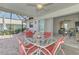 Patio with a dining set overlooking the in-ground pool, lawn chairs, and landscaping at 74 Windsor Dr, Englewood, FL 34223