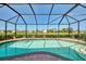 Enclosed pool offering stunning water views, surrounded by brick pavers and lush landscaping at 74 Windsor Dr, Englewood, FL 34223