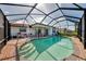 Screened-in pool with brick surround and seating area offers a private outdoor oasis at 74 Windsor Dr, Englewood, FL 34223