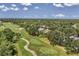 Breathtaking aerial view capturing the expansive golf course and the serene community nestled amidst lush greenery at 7617 Whitebridge Gln, University Park, FL 34201