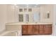 Bright bathroom features double sinks, vanity, large mirror, and separate shower and bath at 7617 Whitebridge Gln, University Park, FL 34201