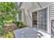 Home exterior featuring sliding glass door, manicured landscaping, and outdoor patio at 7617 Whitebridge Gln, University Park, FL 34201