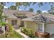 Charming single-story home with tile roof, landscaped front yard, and inviting walkway, blending beauty and functionality at 7617 Whitebridge Gln, University Park, FL 34201