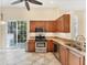 Well-equipped kitchen features granite countertops, stainless steel appliances, and tiled floors at 7617 Whitebridge Gln, University Park, FL 34201