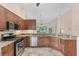 Spacious kitchen with stainless steel appliances, granite counters and tile flooring at 7617 Whitebridge Gln, University Park, FL 34201