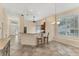 Open-concept living room boasts tile floors, large windows, and breakfast bar with granite countertops at 7617 Whitebridge Gln, University Park, FL 34201