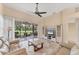 Spacious living room with tile flooring, ceiling fan, neutral walls, and sliding doors to screened patio at 7617 Whitebridge Gln, University Park, FL 34201