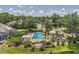 Stunning aerial view of community pool and sunning area surrounded by tropical landscaping and lush green lawn at 7617 Whitebridge Gln, University Park, FL 34201
