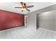 A bedroom featuring tile flooring, a ceiling fan, and a spacious walk-in closet for ample storage at 8075 48Th N Ave, St Petersburg, FL 33709