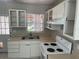 Compact kitchen features white cabinetry, double basin sink, and a bright window at 8075 48Th N Ave, St Petersburg, FL 33709