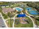 Aerial view of tennis courts, pool, and playground in a well-maintained residential community at 826 Honeyflower Loop, Bradenton, FL 34212