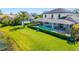 Expansive green lawn with a screened-in pool, trimmed shrubbery, and tranquil pond views at 826 Honeyflower Loop, Bradenton, FL 34212