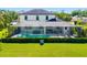 A sprawling backyard featuring a large, screened-in pool, green grass, and neatly trimmed shrubbery at 826 Honeyflower Loop, Bradenton, FL 34212