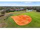Aerial view of a well-maintained baseball field with a dirt infield and grassy outfield at 826 Honeyflower Loop, Bradenton, FL 34212