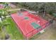 Aerial view of the community basketball court, featuring a red surface with green keys and pristine landscaping at 826 Honeyflower Loop, Bradenton, FL 34212