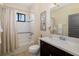 Bright bathroom with a vanity, toilet, shower with curtain, decorative art and a window view at 826 Honeyflower Loop, Bradenton, FL 34212