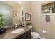 Well-lit powder room featuring a vessel sink, neutral wallpaper, and window with wood blinds at 826 Honeyflower Loop, Bradenton, FL 34212