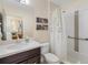 This bathroom features a vanity, toilet, shower with curtain, and neutral wall art and tile at 826 Honeyflower Loop, Bradenton, FL 34212
