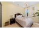 Bright bedroom with a queen bed, two side tables, two windows with curtains, overhead light and wall art at 826 Honeyflower Loop, Bradenton, FL 34212