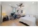 Sun-filled bedroom with hardwood floors, ceiling fan, and an adjacent sitting area with a gray sofa at 826 Honeyflower Loop, Bradenton, FL 34212