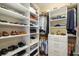 Walk-in closet features custom shelving for storing shoes and folded clothing at 826 Honeyflower Loop, Bradenton, FL 34212