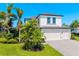 Beautiful two-story home with a three car garage, tropical landscaping, and a brick paver driveway at 826 Honeyflower Loop, Bradenton, FL 34212