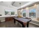 Game room boasts a pool table, mounted screen, natural light, and cozy window seating at 826 Honeyflower Loop, Bradenton, FL 34212