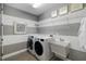 Modern laundry room with front loading washer and dryer next to utility sink and overhead rack at 826 Honeyflower Loop, Bradenton, FL 34212