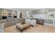 Open-concept living room featuring gray sectional, two white chairs, and hardwood flooring at 826 Honeyflower Loop, Bradenton, FL 34212