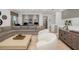 Open-concept living room featuring gray sectional, two white chairs, and hardwood flooring at 826 Honeyflower Loop, Bradenton, FL 34212