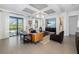 Open-concept living room boasts tile flooring, coffered ceilings, and sliding glass doors to the outdoors at 826 Honeyflower Loop, Bradenton, FL 34212
