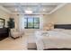 Comfortable bedroom features a decorative ceiling, hardwood floors, and bright natural light at 826 Honeyflower Loop, Bradenton, FL 34212